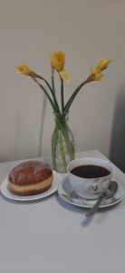 Pączek, kawa, kwiaty w wazonie - Tłusty czwartek