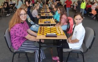 Na zdjęciu dwie dziewczynki grają w szachy